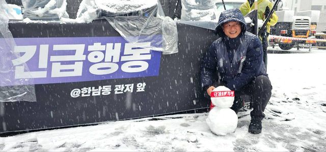 "긴급행동 @한남동 관저 앞" 현수막 앞, 눈사람과 함께