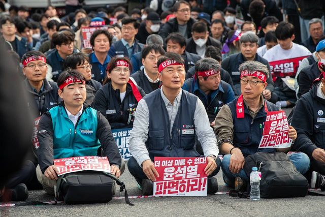 머리띠를 매고 자리에 앉은 조합원들