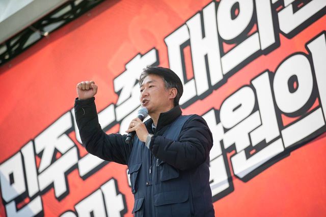 대의원대회 현수막 앞에서 주먹을 든 발언