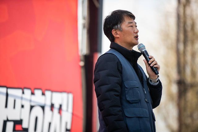 빨간 현수막 옆에서 발언하는 모습