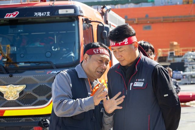 "거제47호" 소방차 앞에서 단결투쟁 머리띠를 맨 조합원과 이야기하는 모습