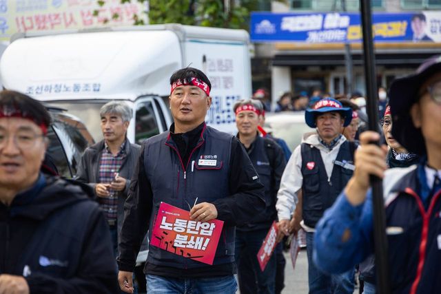 "노동탄압 분쇄!" 손팻말을 들고 조선하청노동조합 차량 앞을 걷는 모습